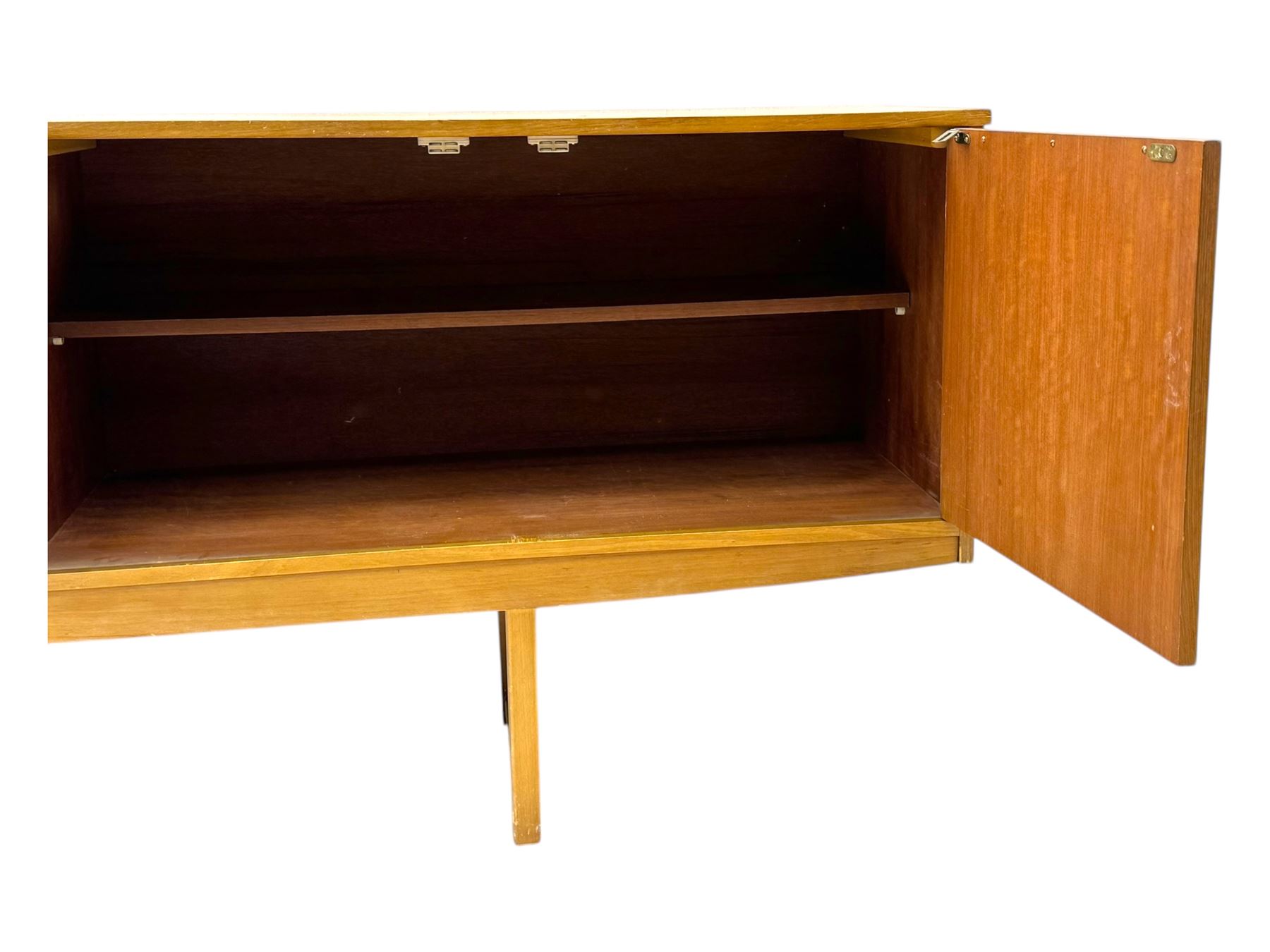 Mid-20th century teak sideboard, fitted with a fall-front cupboard, three drawers including a green baize-lined cutlery drawer, and a double cupboard, with integrated handles, on sleigh supports