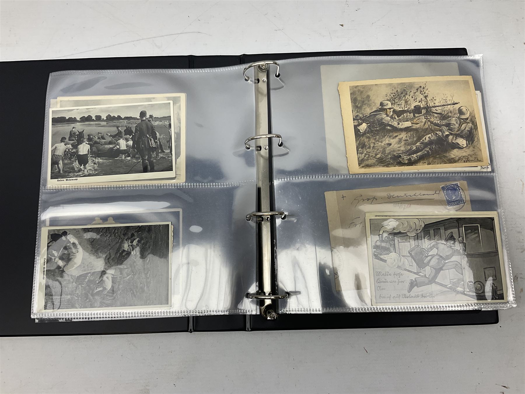 Modern loose leaf album of WW2 German postcards, photographs and other paper ephemera including Adolf Hitler, Luftwaffe, comic, soldier and group portraits, memorial cards, propaganda images, interesting postmarks etc