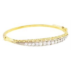 Early 20th century gold and silver diamond hinged bangle, thirteen graduating old cut diamonds, within a fancy scroll design gallery, total diamond weight approx 2.10 carat