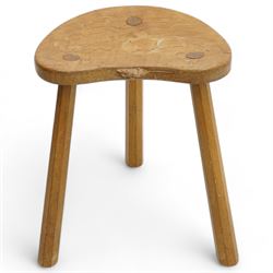 Mouseman - oak three-legged milking stool, dished kidney-shaped seat carved with mouse signature, on three octagonal tapered supports, by the workshop of Robert Thompson, Kilburn