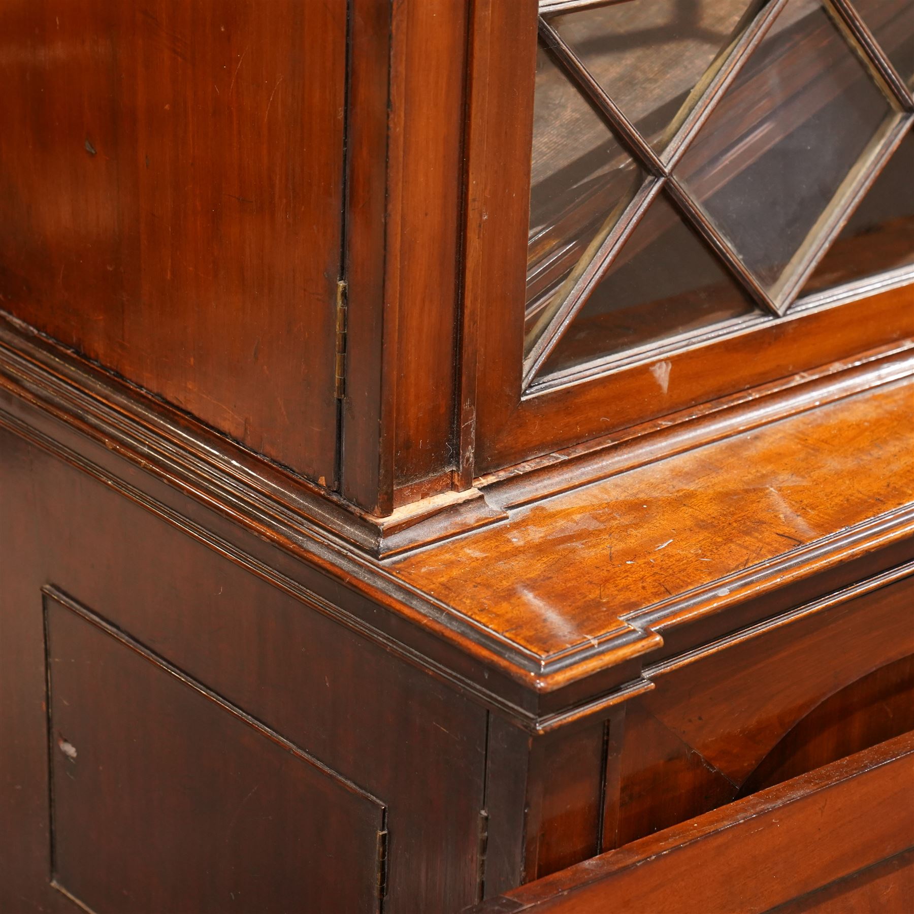 Large Georgian mahogany library bookcase, projecting moulded cornice with row of globular mounts, adjustable shelving enclosed by six astragal glazed doors, fitted with two slides and six panelled cupboard doors, two banks of five drawers, on moulded plinth base; together with two pairs of associated astragal glazed doors in mahogany, from the same property (W55.5cm x H168cm & W48cm x 168cm)