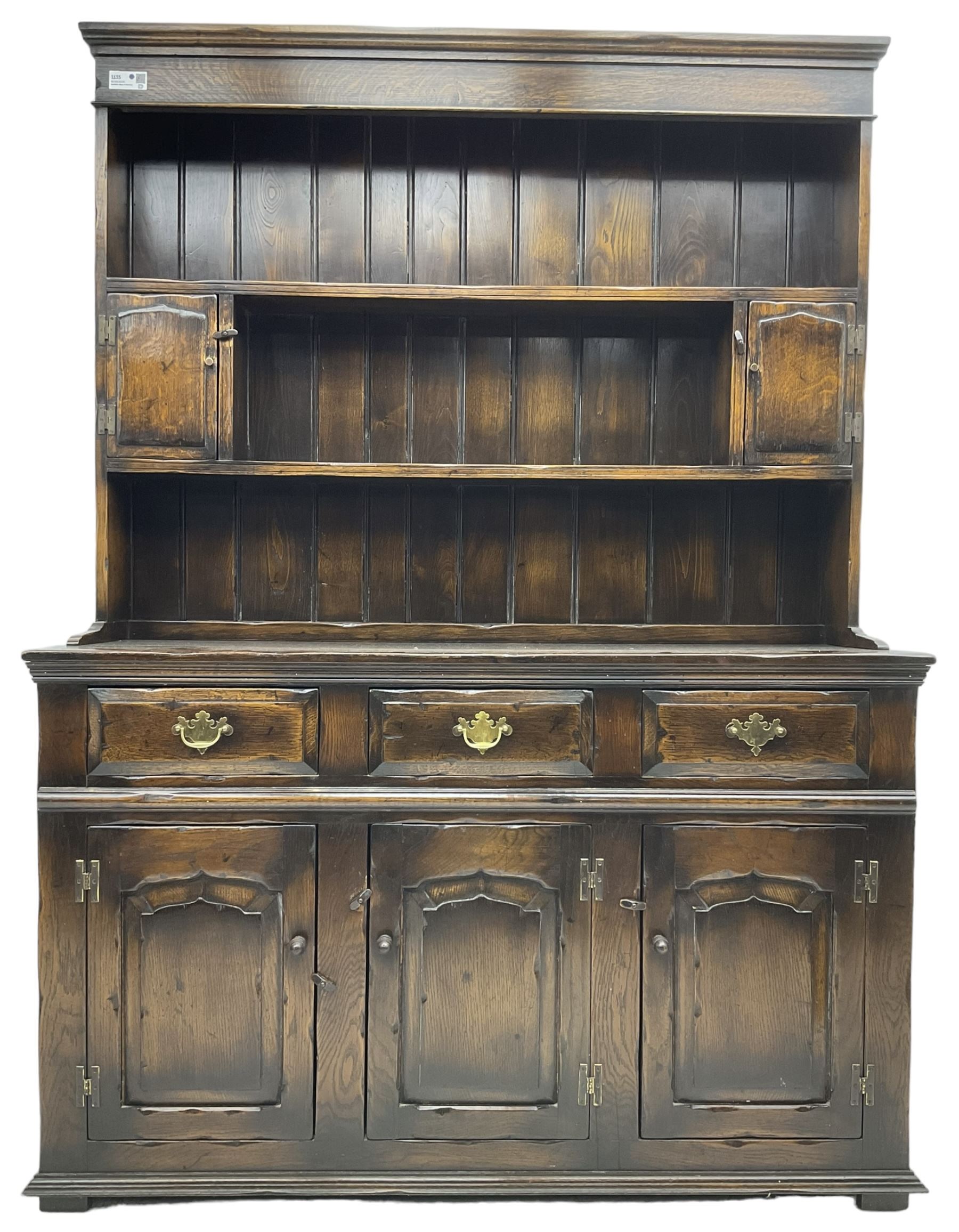 Georgian design oak dresser, the two-tier plate rack with two flanking spice cupboards, the base fitted with three drawers over three arched fielded panelled cupboards, lower moulded edge on block feet