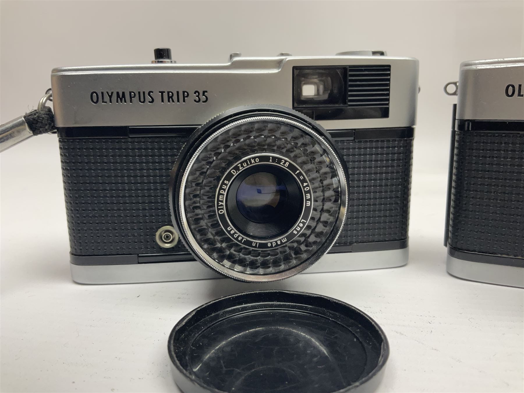 Olympus Pen-EE camera, serial no 415299, with Olympus D.Zuiko 1:3.5 f=2.8cm lens, together with four Olympus Trip 35 cameras, serial nos 4759245, 4257589, 1847727 and 5387611, each with Olympus D. Zuiko 1:28 f=40mm lenses