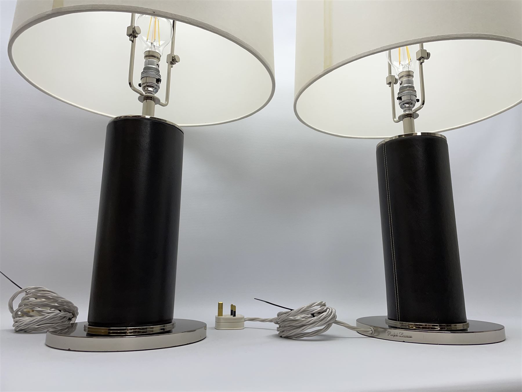 Ralph Lauren - pair 'Beckford' table lamps, cylindrical form in chocolate brown leather, polished metal base, with shades