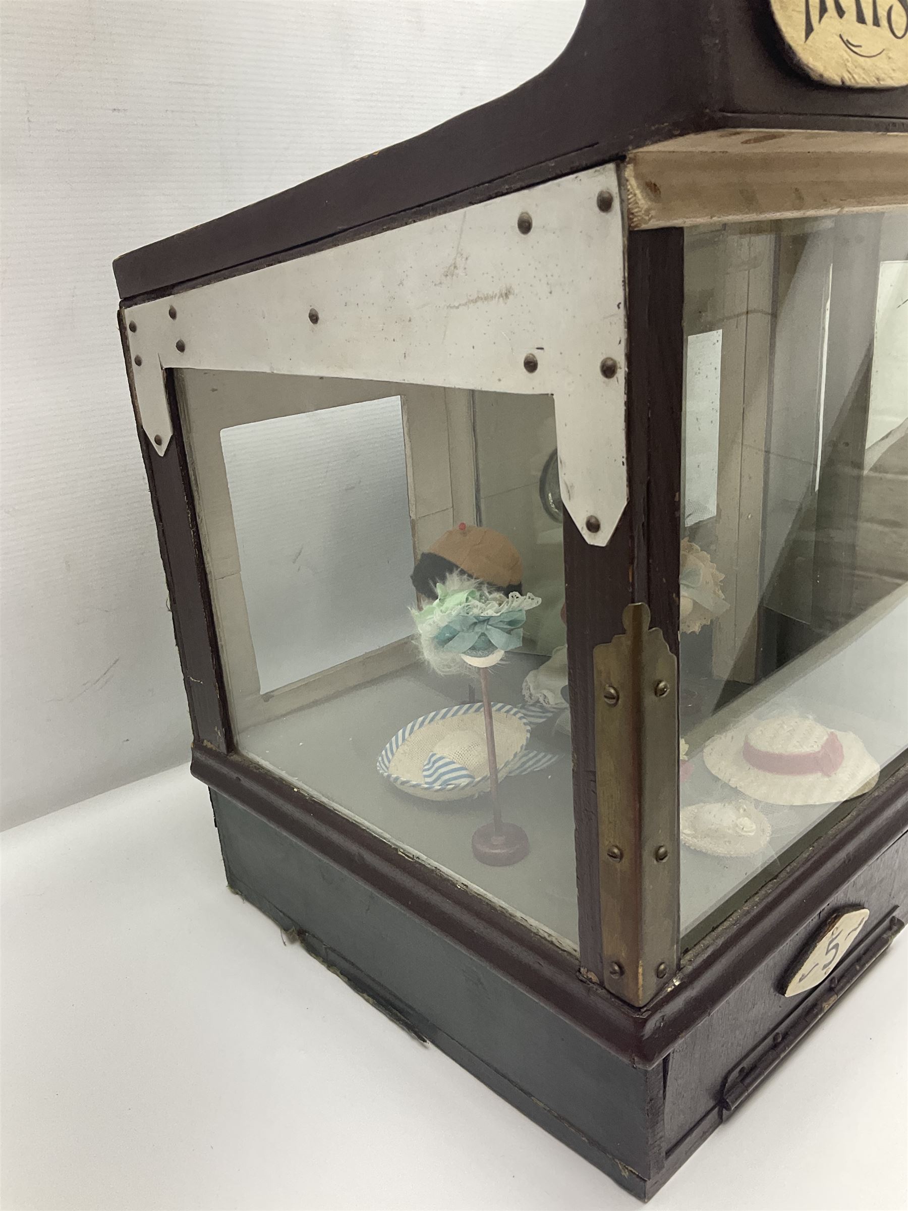 Early 20th century scratch-built wooden hat & gown shop diorama 'Joan', of double-fronted form glazed on three sides with brass and aluminium mounts, rear access apertures and storage under L63cm H45cm D31cm; with small collection of dresses and hats on display stands