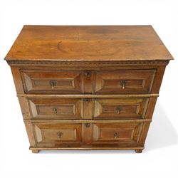 18th century oak chest of drawers, rectangular plank top with chip carved frieze, fitted with three long geometrically panelled drawers with applied mouldings, later brass drop handles, on stile supports, panelled sides and boarded back