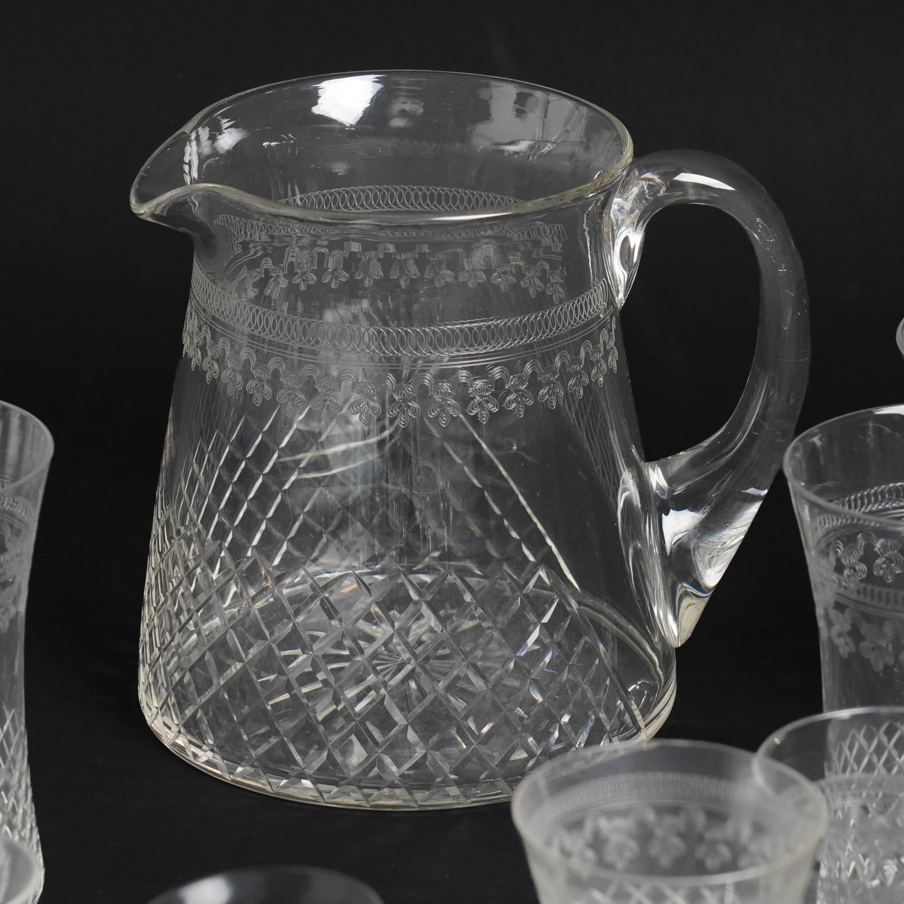 Suite of early 20th century cut and etched table glass comprising nine tumblers, ten smaller tumblers, eleven small wine glasses, six sherry glasses and water jug together with four other sherry glasses