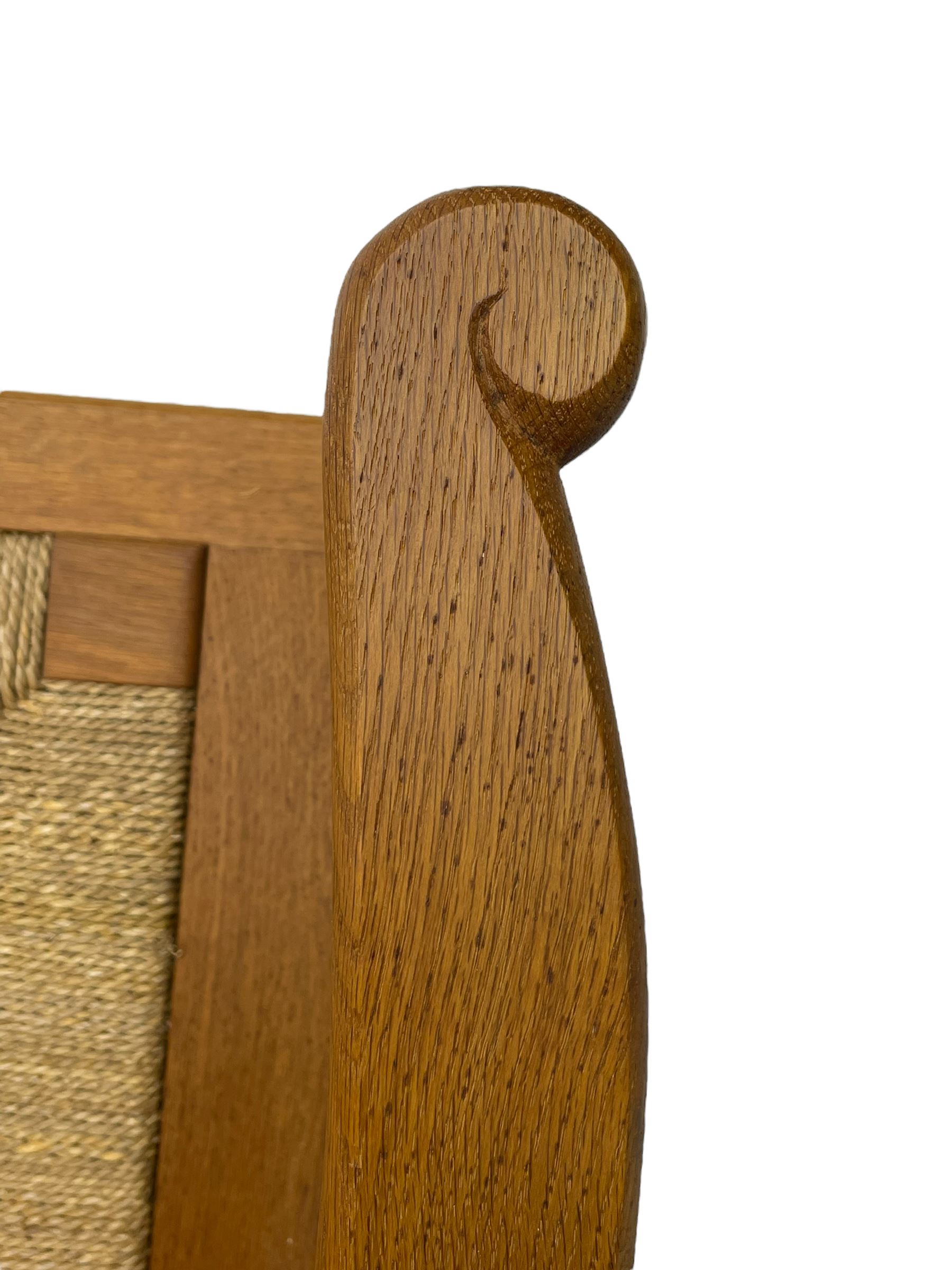 Reynold Eunson (1932–1978) for David Munro Kirkness, Kirkwall, Orkney - oak framed Orkney chair, woven straw canopy back, drop-in rush seat, the arm terminals carved with scrolls, on square tapering supports joined by plain stretchers, the front rail inscribed with makers marks