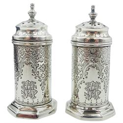 Pair of Victorian silver pepperettes, the bodies of cylindrical form with foliate bright cut engraved decoration and engraved monogram, supporting domed covers with urn finials, upon octagonal bases, hallmarked John Aldwinckle & Thomas Slater, London 1890, contained within a fitted case with purple silk and velvet lined interior, approximate total silver weight 1.86 ozt (58 grams)