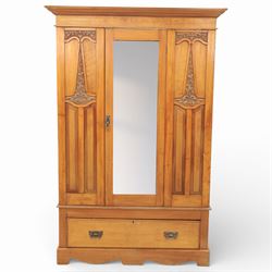 Early 20th century Art Nouveau walnut wardrobe, rectangular top over with single central mirrored panel door, the outer sides carved with sinuous foliate decoration and stylised stem motifs above recessed panels, single long drawer below with brass drop handles, on moulded plinth