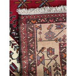 Persian Hamandan rug, the red ground field decorated with triple medallions and stylised motifs