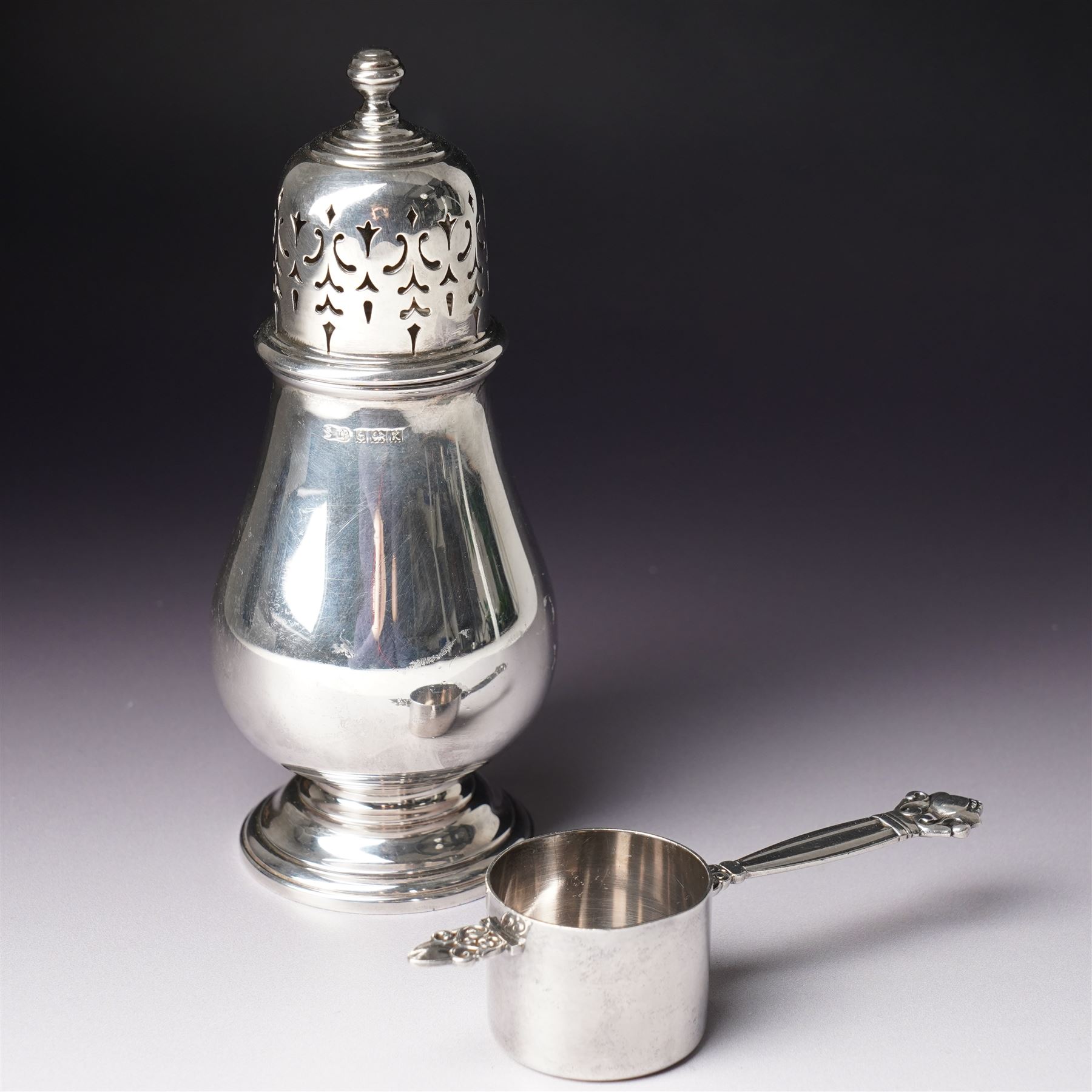 Georg Jensen sterling silver spirit measure of Art Deco design with flattened handle and a silver sugar caster Birmingham 1959