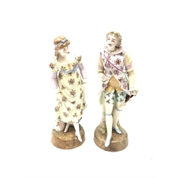 A pair of Continental porcelain figurines, the first modelled as a female figurine in floral dress, the second a male figure in similarly decorated outfit (a/f), each raised upon circular naturalistic base, with painted marks beneath, tallest H32cm, together with a set of six Cauldon China teacups and saucers with gilt key fret border. 