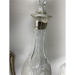 Clear glass decanter of slender oviform with silver collar stamped MN & WB 925, Mappin & Webb, together with an early 20th century silver photo frame hallmarked G & C Ltd of Birmingham, two clear glass shakers with pierced silver tops and silver collared glass storm lampshade with etched decoration, tallest H37.5cm