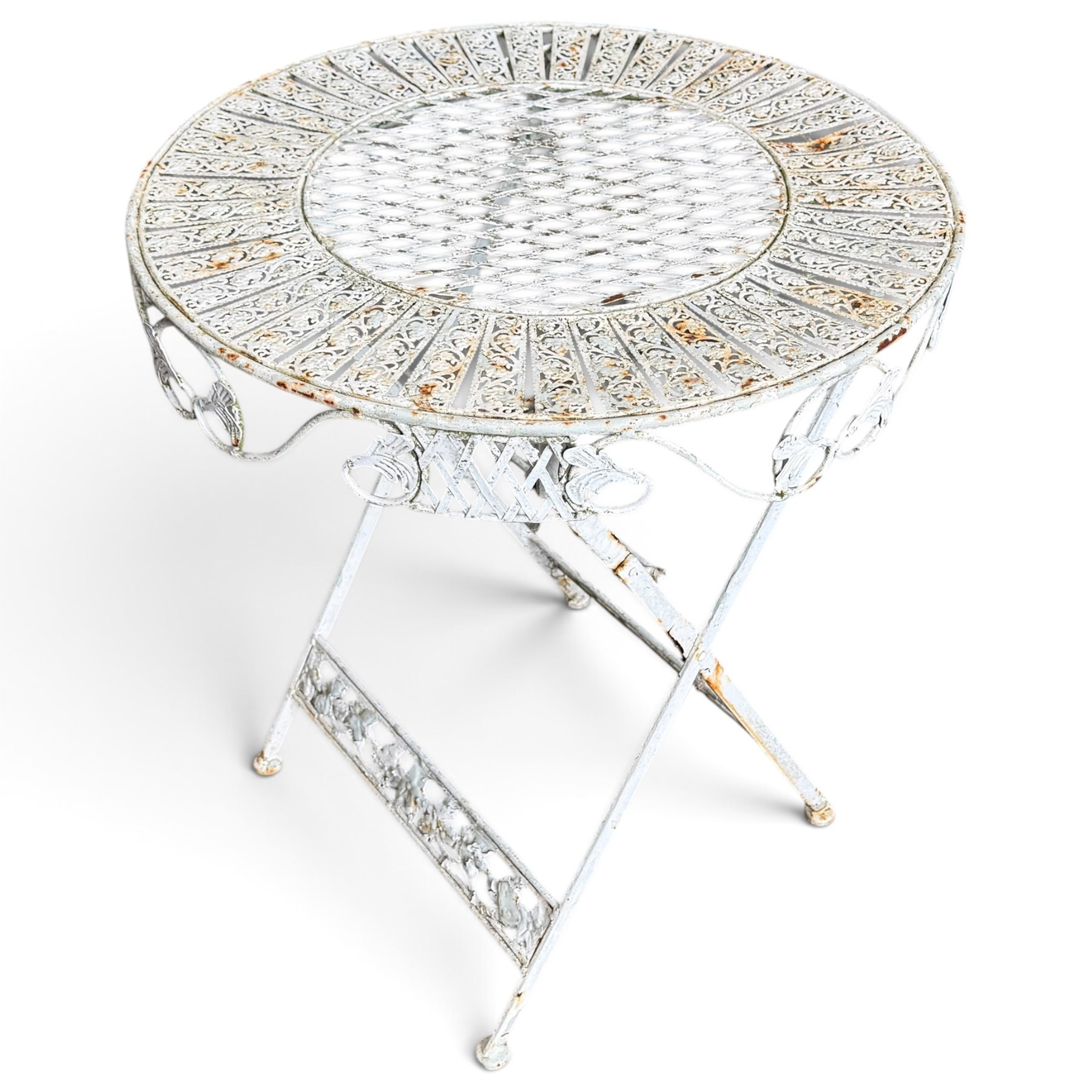 Three-piece French style white-painted wrought iron garden bistro set, comprising a circular folding table with latticework top and apron with scrolling foliate motifs (W70cm H80cm) and matching pair of chairs, with scrolling cresting rail and acorn finials over a scrolled foliate medallion, raised on lattice seat and folding X-frame base (W42cm H93cm)