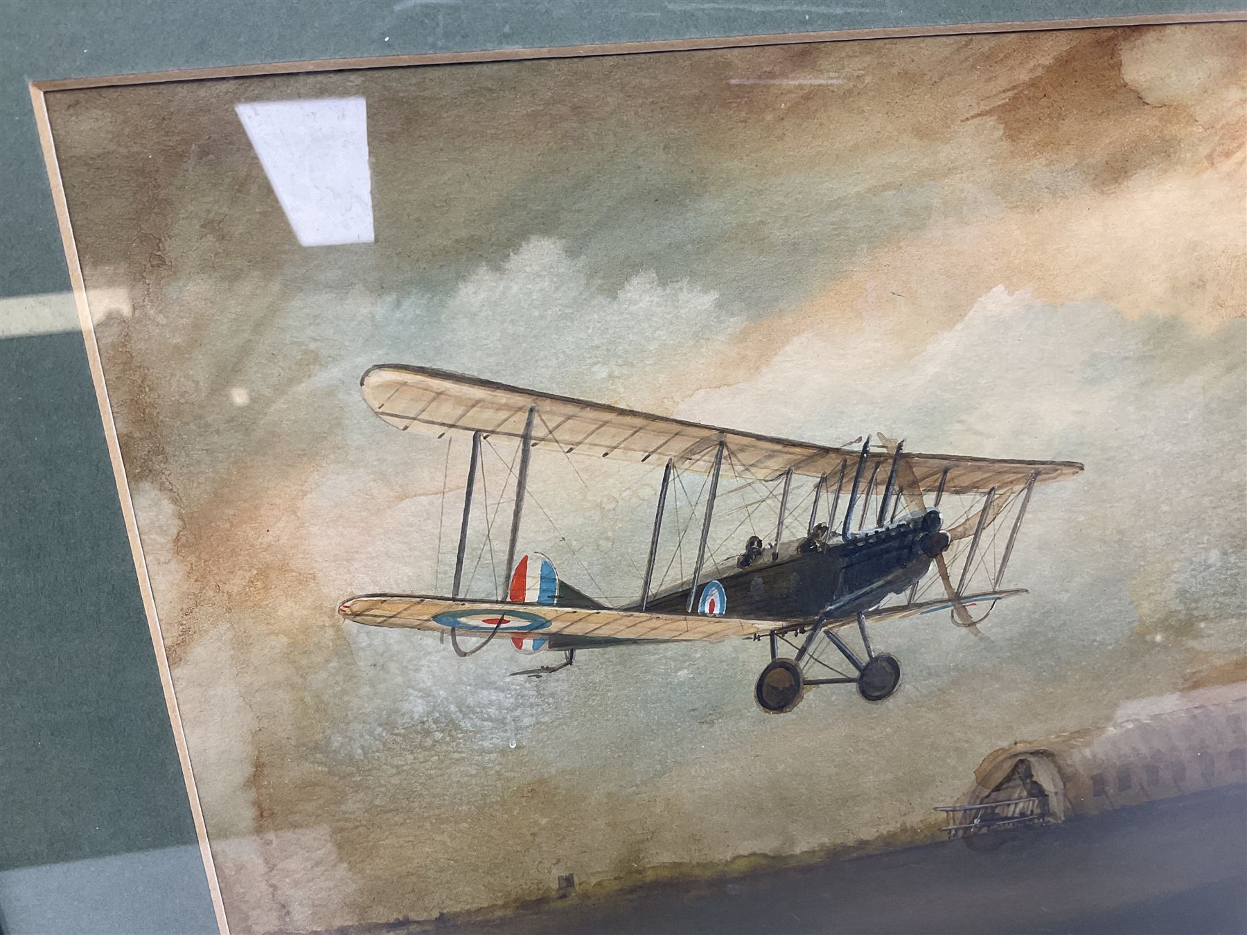 T. Page (early 20th century) - RFC bi-plane in flight over an airfield, bears labels verso 'BE2.B. Dennes Lane R.F.C. Lydd Flying School Oct.1916' and 'Lt. Gerrard R.F.C Lydd 1917 Evening Anti Zeppelin Training Flt. B. Dennes Lane Circum & Bumps', signed watercolour 20.5 x 22.5cm, later mahogany stained frame
