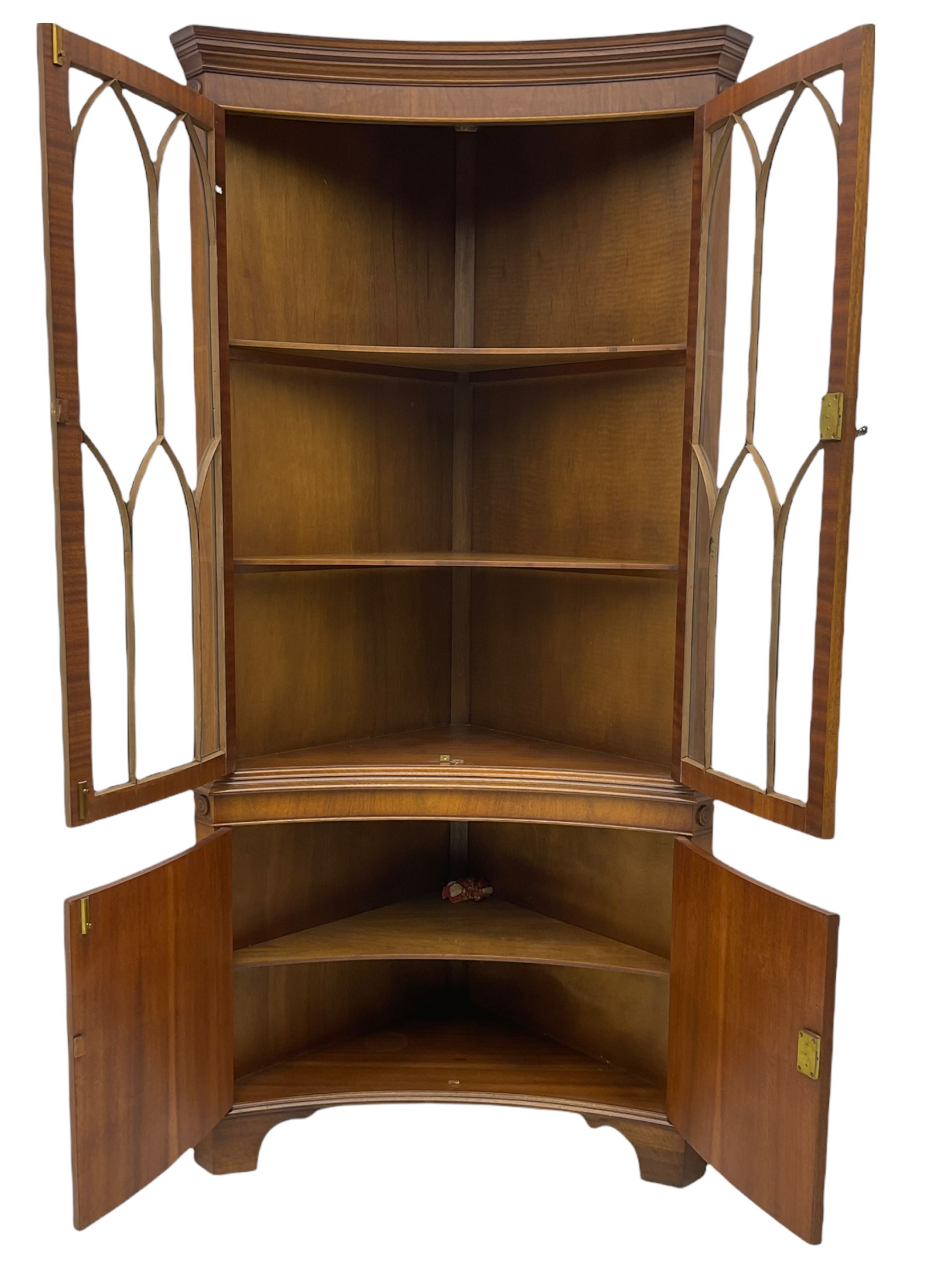 Late 20th century Georgian design mahogany concave corner display cabinet, enclosed by two curved astragal glazed doors, double cupboard below, on bracket feet