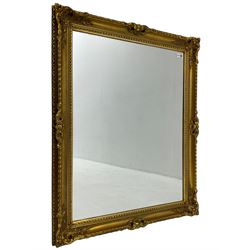Rectangular gilt framed wall mirror, ornate cartouche decorated frame, plain mirror plate