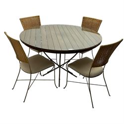 Contemporary teak and metalwork conservatory table, circular plank top with removable glass surface over metal quadriform base (W120cm H75cm); and matching set of four chairs, rattan back over cream upholstered seats, on metalwork base (W40cm H878cm)