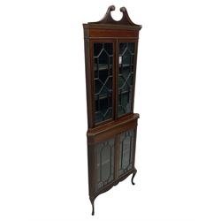 Edwardian mahogany corner display cabinet, scrolled swan neck pediment over astragal glazed doors, fabric lined interior, on cabriole feet 