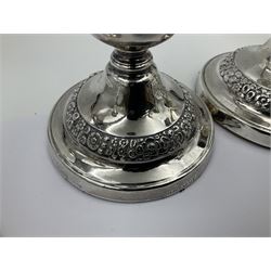 Four George III silver candlesticks, each upon knopped stem and weighted circular stepped foot, the foot and removable sconce repousse decorated with a band of flower heads, hallmarked to sconce and foot Thomas & John Settle, Sheffield 1820, H17.5cm