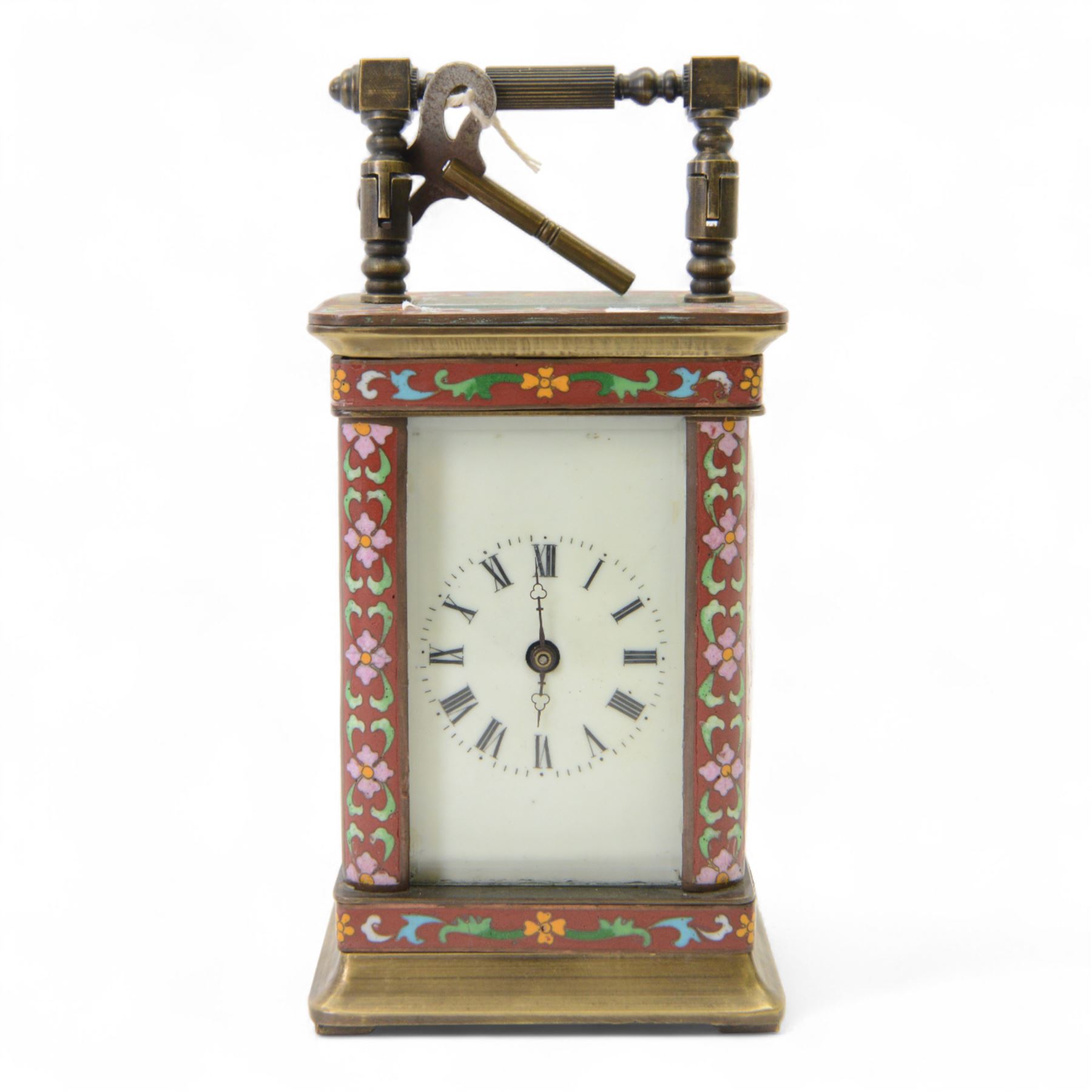 Late 20th century- Chinese 8-day timepiece carriage clock with Cloisonne work on a red ground to the four pillars, base and cornice, with painted porcelain panels to the sides, white enamel dial with Roman numerals and trefoil steel hands, platform escapement wound and set from the rear. With Key.