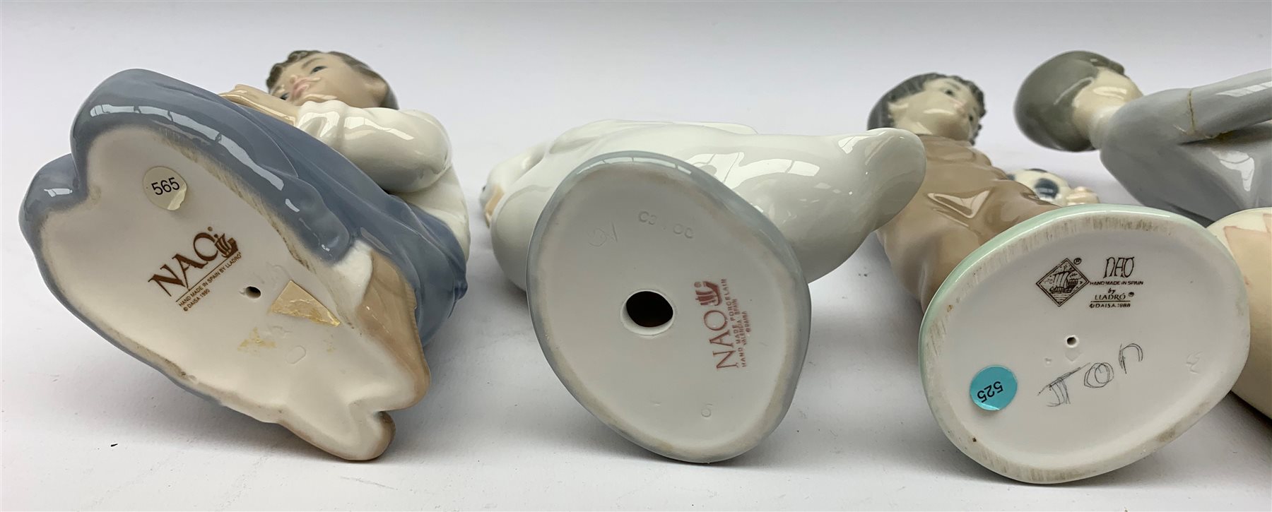  A group of Lladro and Nao figurines, comprising a trio modelled as boys playing instruments, boy with dog, boy with football, girl with puppy and kitten and a goose, (two a/f), all with printed mark beneath.   