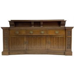 Edwardian oak dresser, the raised back supported by four corbels relief carved with scrolling branch and foliage, moulded top over three drawers, three cupboards below enclosed by panelled doors, the upright carved with foliage motifs, on moulded plinth base