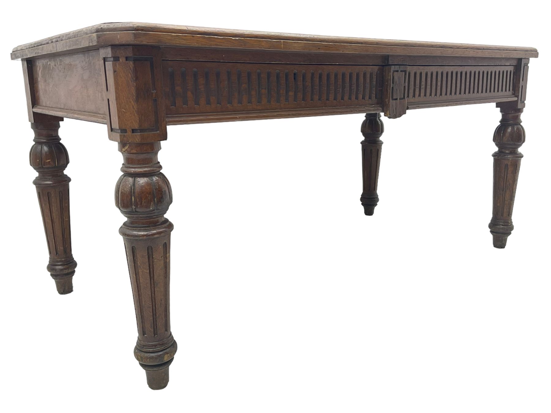 Late 19th century oak library table, moulded rectangular top with canted corners, fitted with two frieze drawers with fluted facias, on lobe carved and fluted turned supports 