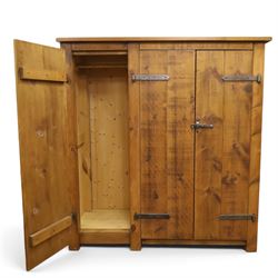 Indigo Furniture - rustic oak triple wardrobe, fitted with three doors with wrought metal fittings and locks, on style supports