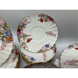 Modern Spode dinner and tea service for eight place settings, comprising dinner plates, dessert plates, side plates, twin handled soup bowls and saucers, oval serving dish, lidded tureen, teapot, teacups, saucers, milk jug, and open sucrier, each of full or part fluted form and decorated with wild flowers predominantly in tones of pink, with red and black printed mark beneath