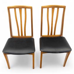 Sutcliffe of Todmorden - mid 20th century ‘S-Form’ teak dining table and chairs, the circular storable extending table with plain veneered top on tapered supports, together with matching dining chairs upholstered in black vinyl, with curved slat backs and shaped front supports, reflecting the sleek organic styling characteristic of 1960s British modern furniture design (Chairs H 93cm, W 46cm, D 46cm) (Extended 168cm)