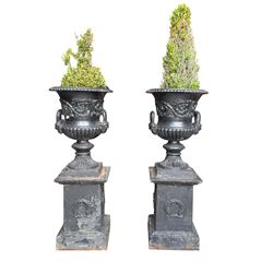 Pair of Victorian cast iron campana form garden urns, the gadrooned flared edge over a scr...