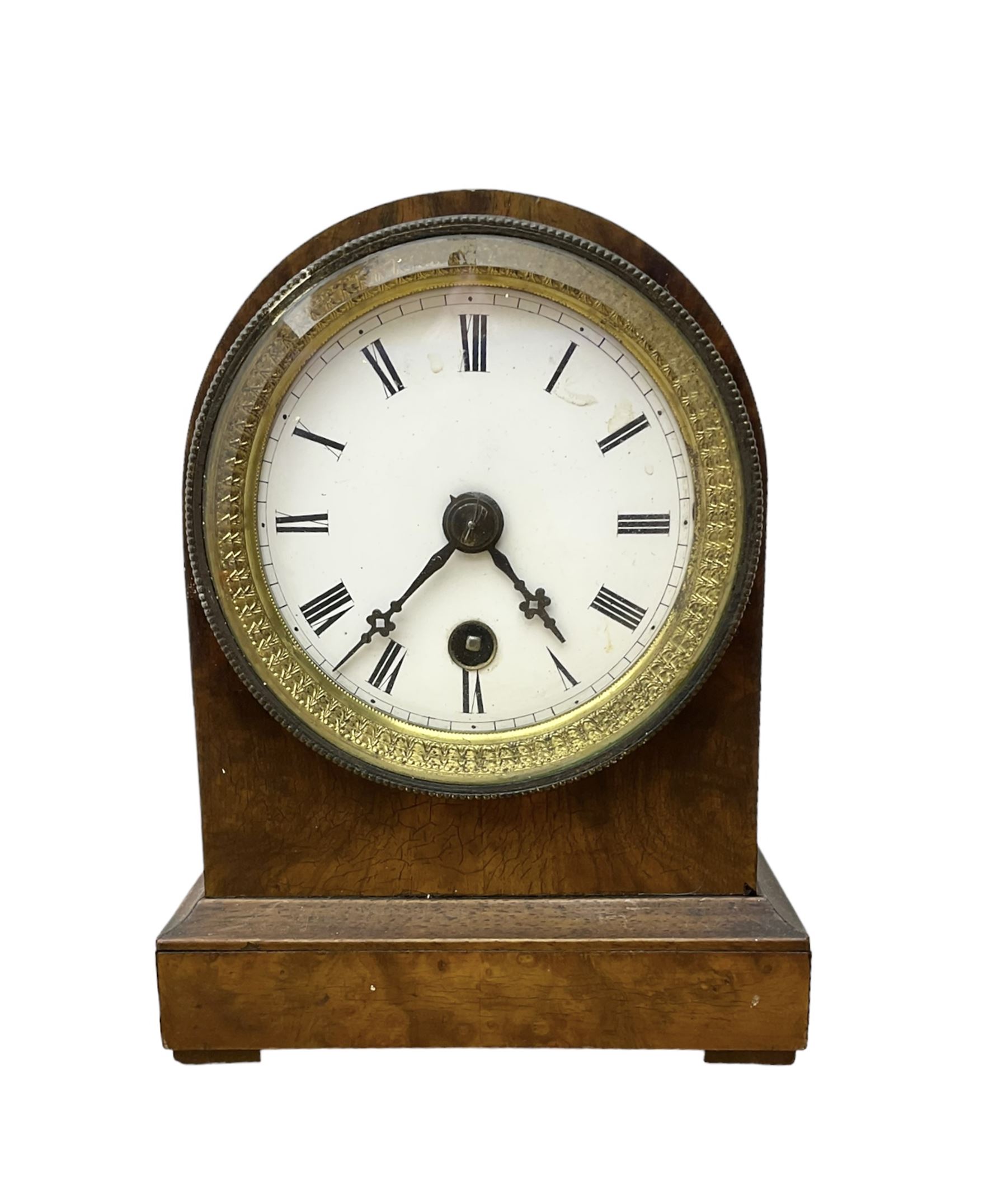 French - late 19th century 8-day walnut table clock, with a round top and shallow plinth raised on block feet, enamel dial with Roman numerals and minute track and decorative pierced steel hands within a gilt slip and cast brass bezel, single train movement with a spring driven going barrel. With pendulum. 
