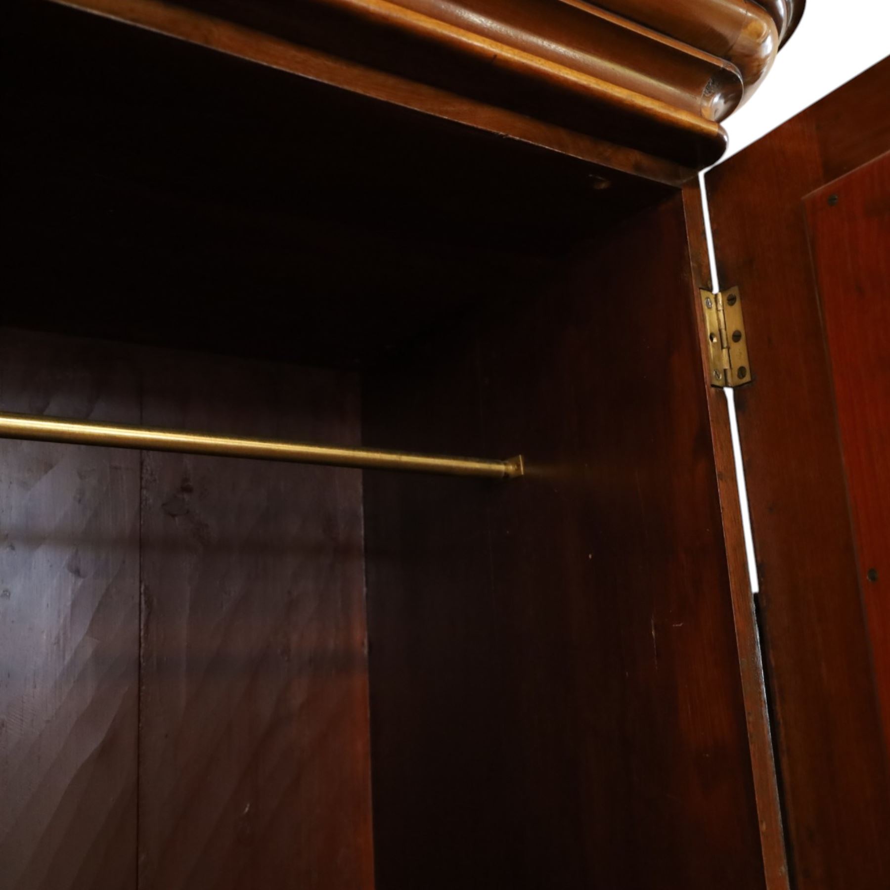 Victorian figured walnut double wardrobe, projecting moulded cornice over twin arched silvered mirrored doors, fitted with hanging rail and drawer with campaign style handle, on plinth base