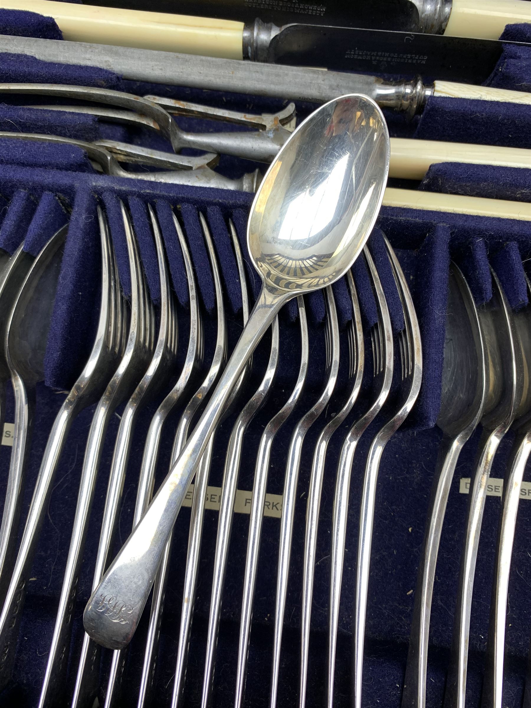 Late 19th/early 20th century composite canteen of silver flatware, contained within an early 20th century mahogany serpentine fronted case with twin drop carry handles, and hinged cover with boxwood stringing and central inlaid shell motif, above a single drawer with twin ring handles and Wellington style locking system, the cover and drawer opening to reveal plaque for Spink & Sons Ltd London, and fitted interior containing ivory handled knives, ivory handled carving set, and silver Hanoverian and Old English pattern cutlery, each with engraved monogram to terminal, hallmarked London, makers Spink & Son (John Marshall Spink), Goldsmiths & Silversmiths Co, and Chawner & Co (George William Adams), various dates ranging 1880-1923, gross weighable silver 92.59 ozt (2880 grams)