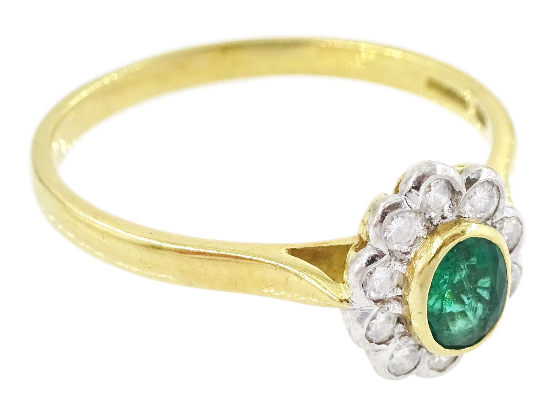 18ct gold emerald and diamond cluster ring, single oval cut emerald of approx 0.25 carat, surrounded by ten round brilliant cut diamonds, Birmingham 1995, total diamond weight approx 0.10 carat