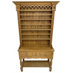 Polished pine dresser, the raised three tier plate rack with projecting cornice over fretwork frieze, the base fitted with three drawers, turned supports united by under-tier 