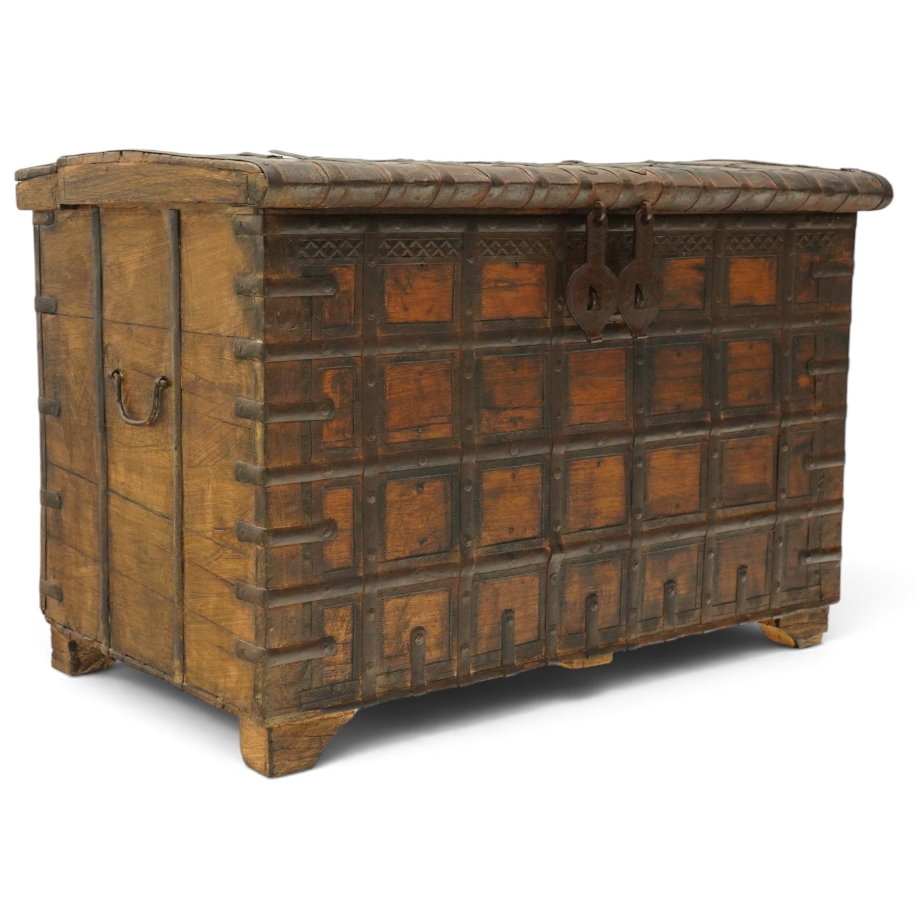 Large 19th century North Indian teak and wrought iron-bound dowry chest, probably Rajasthani, the shallow domed plank lid secured with broad iron straps above a lattice-carved frieze and grid of riveted iron bands, with twin shaped hasps, side carrying handles and fitted interior till, on bracket feet