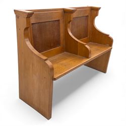 Pair of mid 20th century oak ecclesiastical pews, each with panelled backrests and shaped end supports, of solid construction and mellow honeyed tone