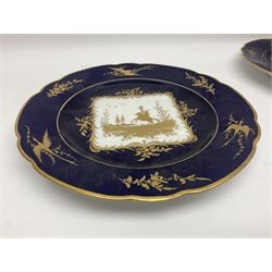 Three Dresden plates, the central panel decorated with a gilt hunting scene, with a bird and floral sprigs border upon a blue ground, with printed mark beneath D22cm 