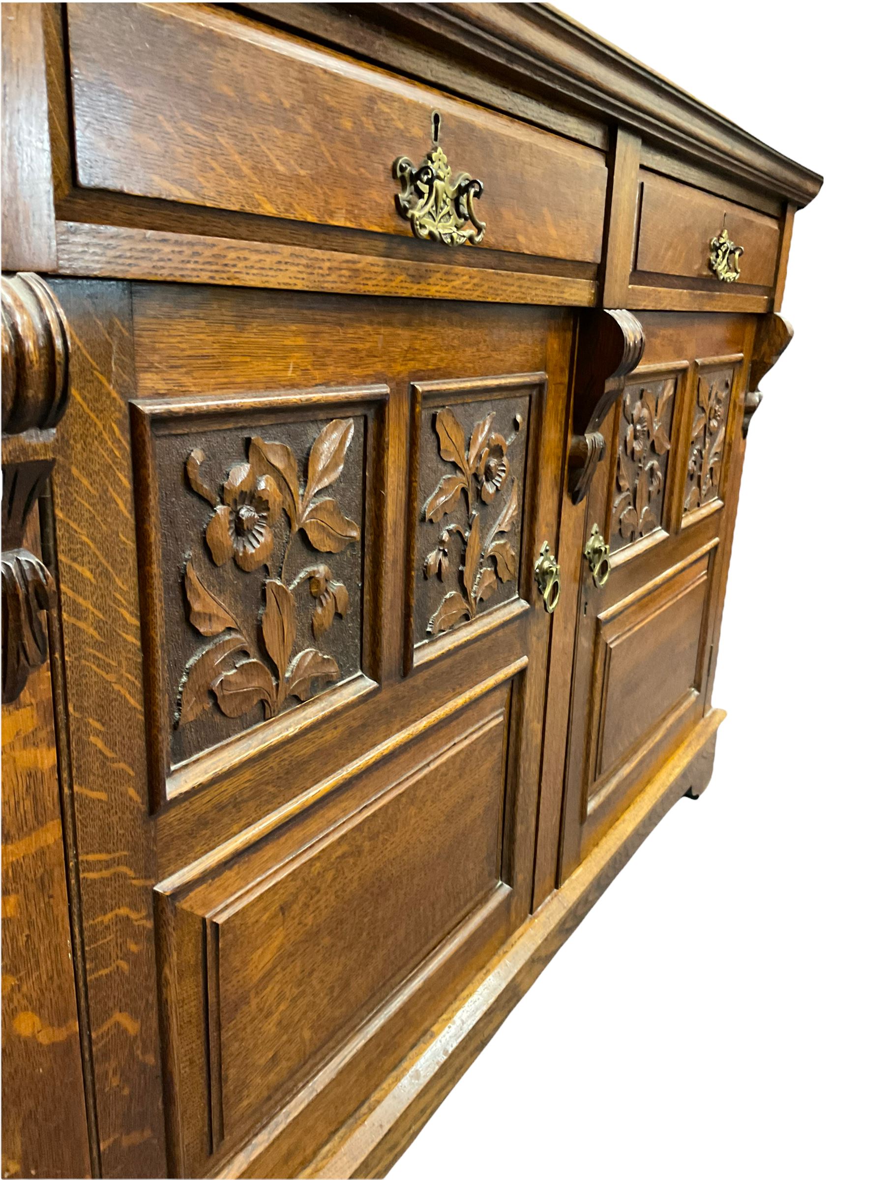 Edwardian oak mirror back sideboard, raised shaped pediment carved with acanthus leaves over Greek key frieze, bevelled mirror back, fitted with two drawers and two cupboards