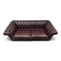 Thomas Lloyd - traditional shape Chesterfield two seater settee with rolled back and arms, upholstered in buttoned deep oxblood leather with loose seat cushions, raised on turned feet