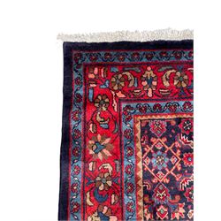 Persian indigo ground rug, the field decorated all over with floral Heratti motifs, crimson border with trailing stylised flower heads, within guard stripes