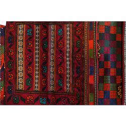 North East Persian Turkoman saddle bag, traditional double pouch form, each panel with madder red ground, decorated with horizontal bands of stylized geometric floral motifs and angular vine work, framed simple borders, central panel woven in flatweave with polychromed chequered design flanked by braided carrying cords with tasselled and knotted decorative elements 