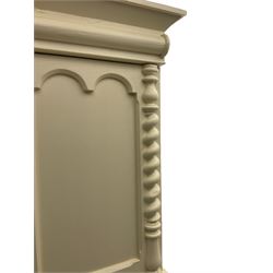 Victorian cream painted pine cupboard-on-chest or housekeeper's cupboard, projecting cornice over two double-arch panelled cupboard doors enclosing two shelves, flanked by spiral turned uprights, base fitted with two short over two long drawers, on bun feet