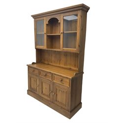 Polished traditional pine dresser, the raised back fitted with two display cabinets, the base fitted with three drawers and three cupboards