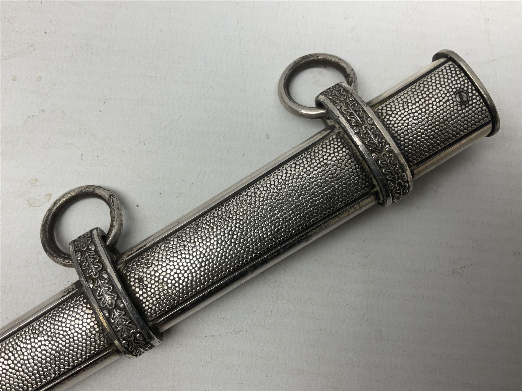 Late WW2 German Army Officers dress dagger, with unmarked 25cm double edged steel blade, orange celluloid grip, pommel and ferrule with oakleaves relief and cross guard with eagle; in original beaded scabbard with two hanging rings L39.5cm overall