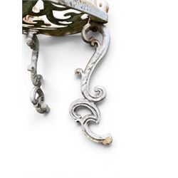 Pair of Victorian cast iron garden chairs, the ornate pierced back of scrolling foliate design, scrolling arm terminals over splayed supports formed of C and S-scrolls, in distressed white painted finish