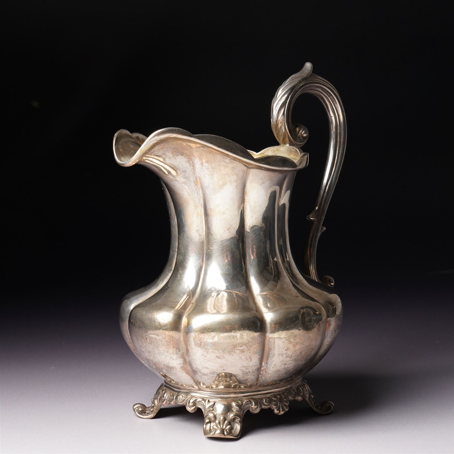 Victorian silver cream jug of panel sided baluster form with crimped rimand scroll handle on shaped supports London 1840 Maker Charles Gordon  